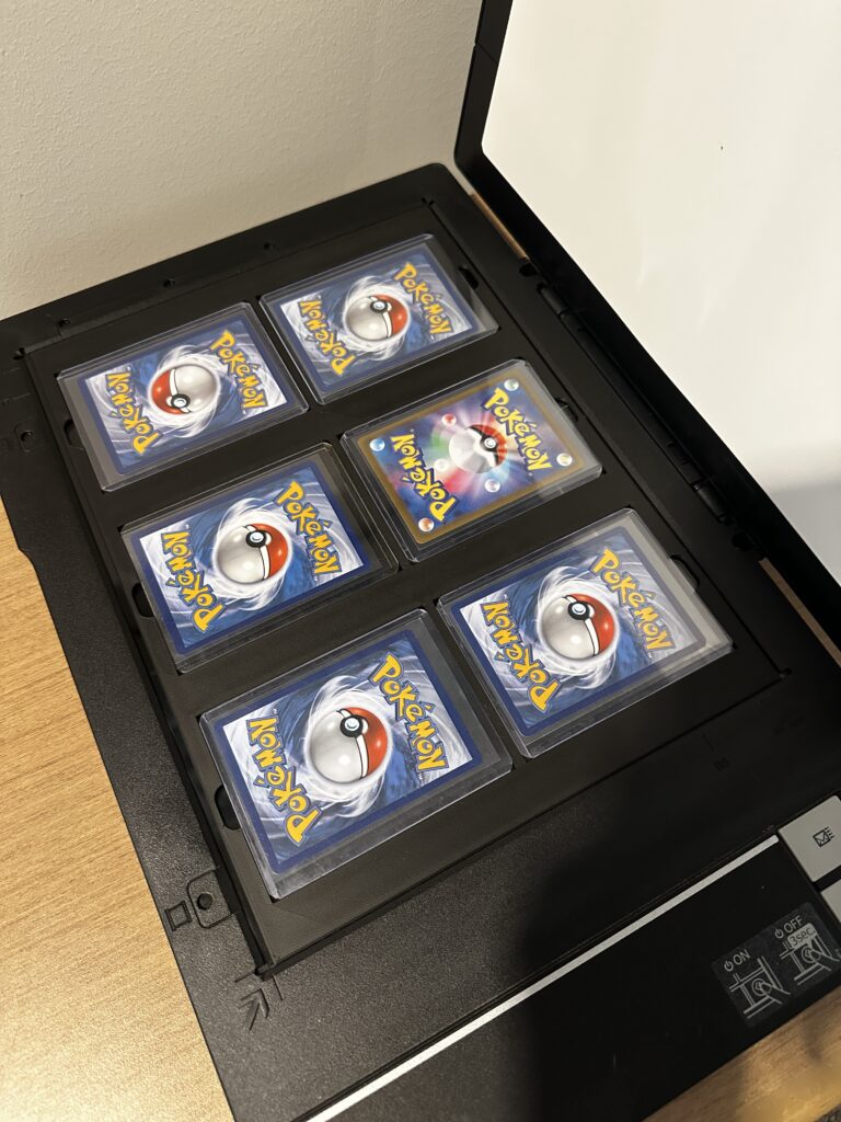 TopDock on a flatbed scanner, loaded with 6 toploaded Pok&eacute;mon cards